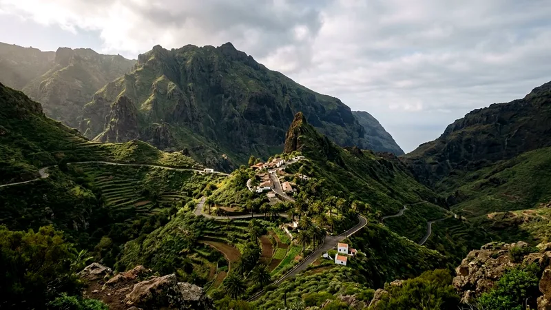 Masca village perched on a ridge among steep green Teno mountain peaks.