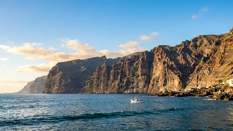 Towering Los Gigantes cliffs rising from the Atlantic Ocean at golden hour.